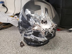 Manitoba RCMP photo shows damage suffered by 54-year-old Winnipeg snowmobiler who was involved in a collision with another snowmobile on Feb. 21, with RCMP crediting his safety equipment with preventing serious injury. A hole in the rider’s helmet went almost all the way through. His jacket had extra protection padding, which was exposed and scraped up. If he had not been wearing this equipment, RCMP believe he likely would not have survived the accident.