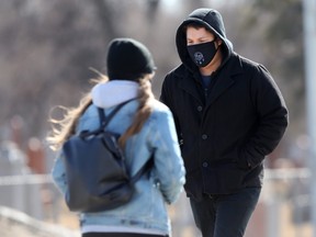 People outside wearing masks in Winnipeg on Friday, March 12, 2021.