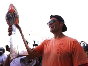 Tampa Bay Buccaneers quarterback Tom Brady holds the Vince Lombardi Trophy during a boat parade to celebrate victory in Super Bowl LV against the Kansas City Chiefs.