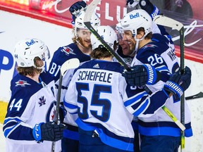 Winnipeg Jets forward Blake Wheeler (26) celebrates his power play goal with teammates against the Calgary Flames during the first period at Scotiabank Saddledome in Calgary on Friday, March 26, 2021.