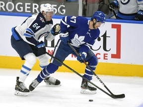 Toronto Maple Leafs forward Pierre Engvall (47) battles for the puck with Winnipeg Jets defenceman Logan Stanley (64) in the first period at Scotiabank Arena in Toronto on Saturday, March 13, 2021.