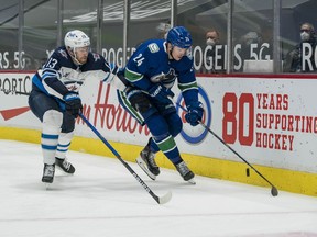 Winnipeg Jets forward Pierre-Luc Dubois (13) plays for the puck against Vancouver Canucks forward Jimmy Vesey (24) in the second period at Rogers Arena in Vancouver on Wednesday, March 24, 2021.