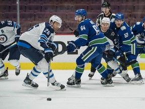 Vancouver Canucks forward Tyler Motte (64) checks Winnipeg Jets forward Blake Wheeler (26) in the second period at Rogers Arena in Vancouver on Mnday, March 22, 2021.