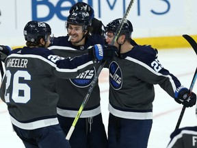 Winnipeg Jets forward Paul Stastny (right) celebrates his goal against the Vancouver Canucks in Winnipeg with Mark Scheifele (centre) and Blake Wheeler on Tuesday, March 2, 2021.