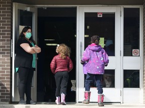 Students head inside Victor Mager School on Beliveau Road in Winnipeg on Monday.