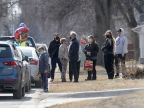 An outdoor gathering where people are wearing masks enjoy the first day of spring in Winnipeg on Saturday, March 20, 2021.