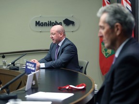 Dr. Brent Roussin, chief provincial public health officer, speaks with Premier Brian Pallister looking on during a COVID-19 briefing at the Manitoba Legislative Building in Winnipeg on Tuesday, March 23, 2021.