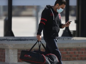 A person wears a mask while carrying a bag of food, in Winnipeg on Saturday March 27, 2021.