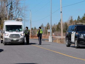 Kenora OPP officers question motorists entering Ontario at the rest stop at the provinical border with Manitoba on Monday, April 19. The Ontario government has placed restrictions on inter-provincial travel amid rising COVID-19 cases. Ryan Stelter/Miner and News/Postmedia Network