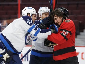 Logan Stanley of the Winnipeg Jets shoves Ottawa Senators' Alex Formenton during Wednesday's game.