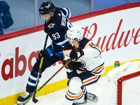 Oilers’ Josh Archibald (left) checks Kristian Vesalainen on Wednesday.