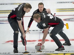 Canada skip Brendan Bottcher delivers his stone as second Brad Thiessen (left) and lead Karrick Martin (right) brush during Draw 4 against Denmark.