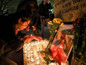 A person lights a candle during a vigil following the fatal police shooting of 20-year-old Black man Daunte Wright in Minnesota, in Washington, D.C., Monday, April 12, 2021.