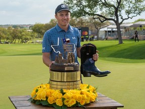Jordan Spieth holds the trophy and champion's boots after winning the Valero Texas Open golf tournament in San Antonio, Texas, April 4, 2021.