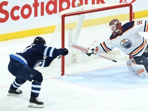 Jets defenceman Josh Morrissey (left) can't get the puck past Edmonton Oilers goaltender Mikko Koskinen in Winnipeg on Wednesday night.