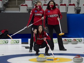 Team Canada skip Kerri Einarson of Gimli, Man., crouches in the rings as (back L-R), national team coaches Heather Nedohin and assistant national team coach Renee Sonnenberg during practice on April 29, 2021, before the start of the world women's curling championship in Calgary.