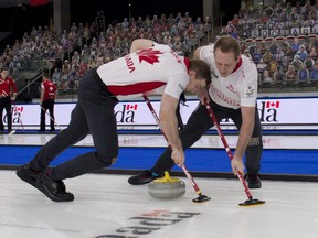 Team Canada second Brad Thiessen (left) and lead Karrick Martin (right) brush the stone during Draw 22 against Team Germany at the Men's World Curling Championship at WinSport Arena in Calgary, Friday, April 9, 2021.