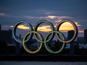 A general view shows the Olympic rings lit up at dusk on the Odaiba waterfront in Tokyo on April 28, 2021.