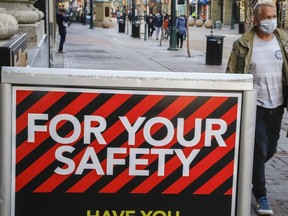 A man wears a mask in downtown Calgary, Alta., Friday, Oct. 30, 2020, amid a worldwide COVID-19 pandemic.