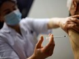 A healthcare worker administers a dose of tPfizer BioNTech COVID-19 vaccine.