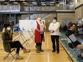 Thompson Mayor Colleen Smook, centre right, and Helga Bryant of the Northern Regional Health Authority, centre left, oversee first vaccinations at the Thompson Regional Community Centre on Feb. 1. Photo by Kacper Antoszewski