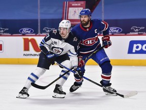 Pierre-Luc Dubois (13) of the Winnipeg Jets and Shea Weber (6) of the Montreal Canadiens skate against each other during the third period at the Bell Centre on April 10, 2021 in Montreal.  Winnipeg Jets defeated the Montreal Canadiens 5-0.