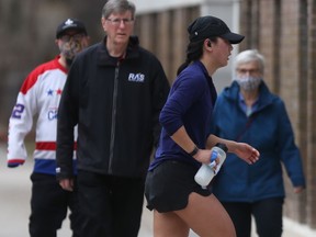 A group of three people walking, and one person running, in Winnipeg on Saturday, April 3, 2021.