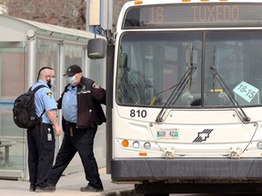 Winnipeg Transit drivers exchange a bus in the Osborne Village area of Winnipeg on Monday, April 5, 2021.