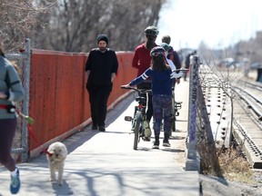 People walk over a bridge in Winnipeg on Saturday, April 10, 2021.