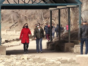 Women wearing masks walk on the river trail near The Forks historic port in Winnipeg on Sunday, April 11, 2021.