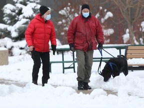 Two people wear masks while walking with a dog, in Winnipeg on Wednesday, April 14, 2/2021. Chris Procaylo/Winnipeg Sun