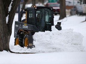 A machine pushes snow off a path in Winnipeg on Thursday, April 15, 2021. Chris Procaylo/Winnipeg Sun