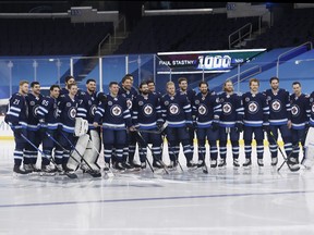Winnipeg Jets players pose with centre Paul Stastny (25) as he celebrates his 1,000th game after the Wednesday's tilt against the Vancouver Canucks.