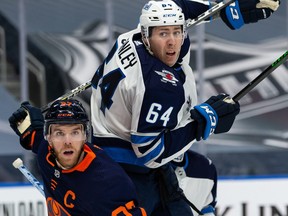 Edmonton Oilers’ Connor McDavid (97) battles Winnipeg Jets’ Logan Stanley (64) during the third period of NHL North Division playoff action at Rogers Place in Edmonton, on Wednesday.