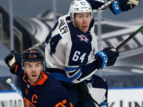 Edmonton Oilers’ Connor McDavid (97) battles Winnipeg Jets’ Logan Stanley (64) during the third period of NHL North Division playoff action at Rogers Place in Edmonton, on Wednesday.