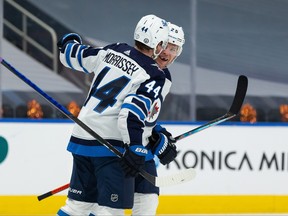 The Winnipeg Jets’ Josh Morrissey (44) congratulates Paul Stastny (25) on his overtime goal during Game 2 of their NHL North Division playoff series at Rogers Place in Edmonton, on Friday, May 21, 2021.