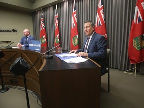 Manitoba Education Minister Cliff Cullen (right) and Dr. Brent Roussin, chief provincial public health officer speak at a COVID-19 press conference at the Manitoba Legislature in Winnipeg on Sunday. Additional COVID-19 measures for schools including closures were announced.
