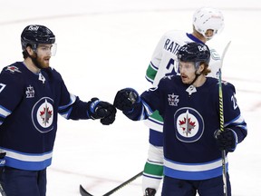 Winnipeg Jets forward Mason Appleton (22) celebrates his third period goal with Adam Lowry against the Vancouver Canucks on Tuesday night at Bell MTS Place.