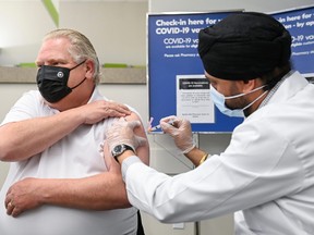 Ontario Premier Doug Ford receives the AstraZeneca vaccine from pharmacist Anmol Soor at Shoppers Drug Mart in Toronto on April 9, 2021.