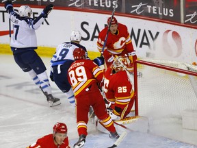 Calgary Flames goalie Jacob Markstrom is scored on by Winnipeg Jets Adam Lowry in first period NHL action at the Scotiabank Saddledome in Calgary on Wednesday, May 5, 2021.