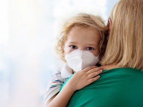 Mother and child with face mask and hand sanitizer