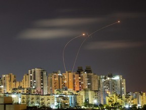 Streaks of light are seen as Israel's Iron Dome anti-missile system intercepts rockets launched from the Gaza Strip towards Israel, as seen from Ashkelon, Thursday, May 20, 2021.