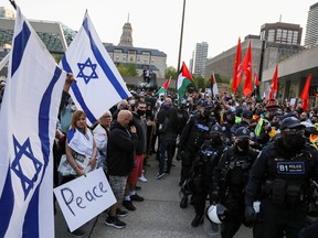 Police officers stand in line to separate protesters supporting Palestine from a small group of Israel supporters in front of city hall in Toronto May 15, 2021.