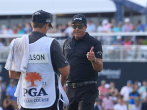 Phil Mickelson gives a thumbs-up to his caddie after playing a shot on to the 18th green during the third round of the PGA Championship at Kiawah Island Resort's Ocean Course on Saturday in Kiawah Island, S.C.