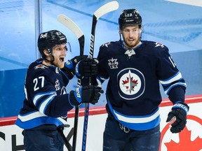 Nikolaj Ehlers (left)  and Pierre-Luc Dubois celebrate a Winnipeg Jets goal in April. Neither played in Game 1 of the Jets' playoff opener.