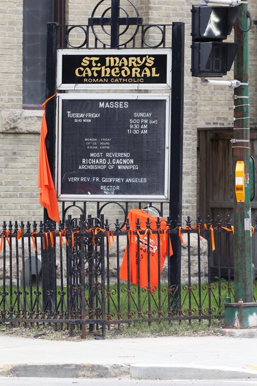 An orange shirt and other items hang outside St. Mary's Cathedral, a Roman Catholic Church in downtown Winnipeg on Sunday, May 30, 2021, in memory of the 215 children's bodies discovered at the former Kamloops Indian Residential School in Kamloops, B.C.