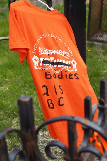 An orange shirt and other items hang outside St. Mary's Cathedral, a Roman Catholic Church in downtown Winnipeg on Sunday, May 30, 2021, in memory of the 215 children's bodies discovered at the former Kamloops Indian Residential School in Kamloops, B.C.
