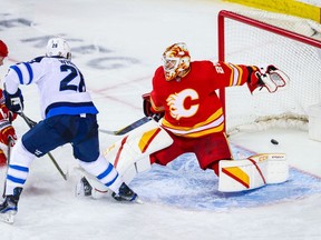 Winnipeg Jets right wing Blake Wheeler (26) scores a goal against Calgary Flames goaltender Jacob Markstrom (25) during the third period at Scotiabank Saddledome.  Sergei Belski-USA TODAY Sports