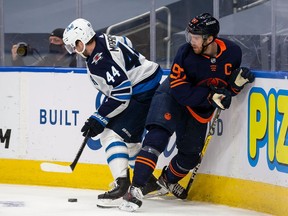 Connor McDavid #97 of the Edmonton Oilers battles against Josh Morrissey #44 of the Winnipeg Jets during Game One of the First Round of the 2021 Stanley Cup Playoffs at Rogers Place on May 19, 2021 in Edmonton, Canada.