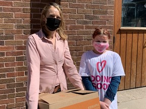 1JustCity Executive Director Tessa Whitecloud (left) accepts a donation of food from 11-year-old Danika Huff at 1JustCity's West End Drop-in site in Winnipeg on Saturday, May 8, 2021. The 11-year-old collected over 600 items for 1JustCity's food supplement program including McDonald's coffee cards. Danika's donation was the third of the day for 1JustCity which also received donations of clothing, menstruation products and cash.